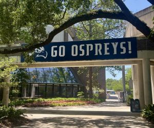 Blue and white “Go Ospreys!” banner outside of Thomas G. Carpenter Library.