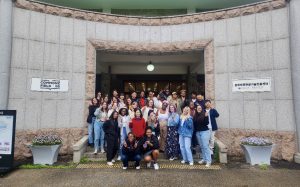 Students studying abroad in Daejeo, South Korea smile for a photo together underneath an arch on stair steps.
