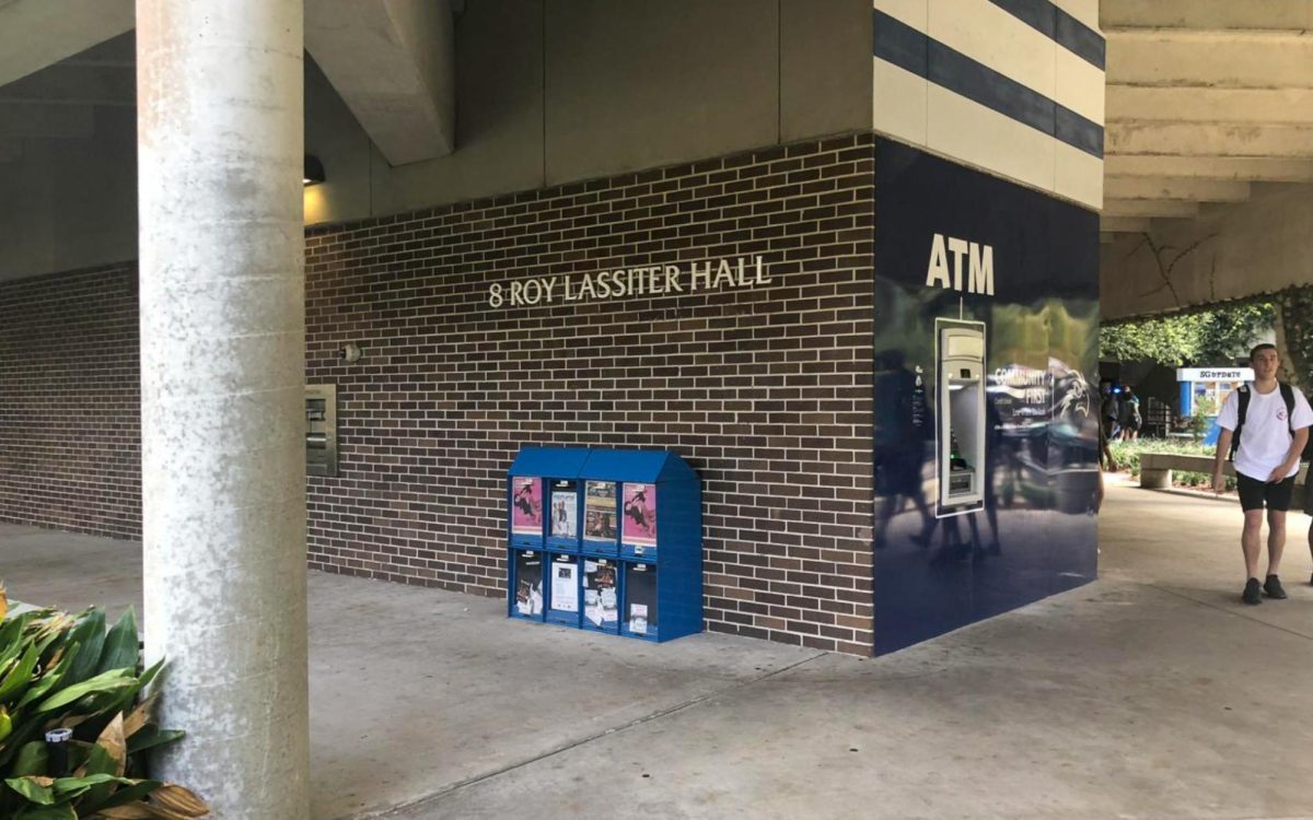 The corner of a brick building with the title "8 Roy Lassiter Hall" on the side in white letters.