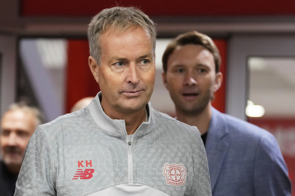 Danish coach Kasper Hjulmand, center, arrives with Bayer sporting director Simon Rolfes, right, to a presention as new head coach of Bundesliga soccer club Bayer Leverkusen at a press conference at the BayArena in Leverkusen, Germany, Wednesday, Sept. 10, 2025. (AP Photo/Martin Meissner)