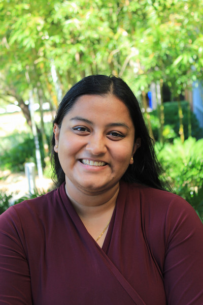 Asvidhi Ladumor, student government supervisor of elections, smiles, wearing a dark red blouse and her hair down.