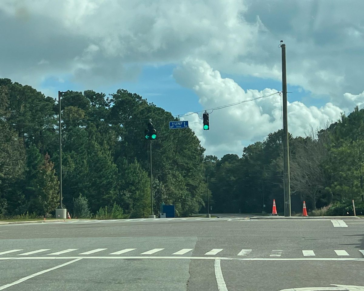 An intersection with a green stoplight and a street sign reading "UNF Drive."