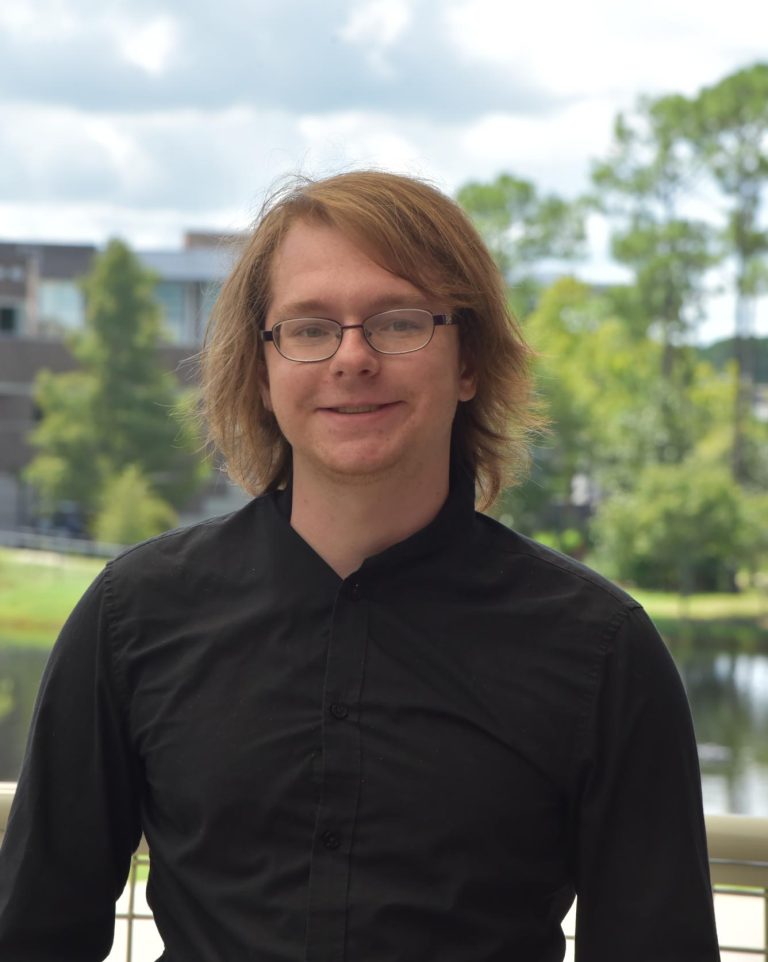 Matthew Fiedler is smiling, wearing a black button-down shirt