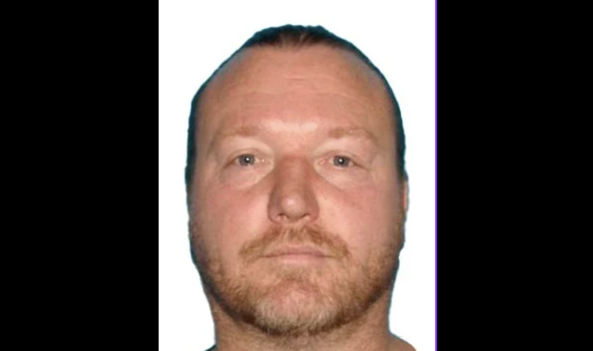 A white man with a short beard is in profile, looking into the camera.