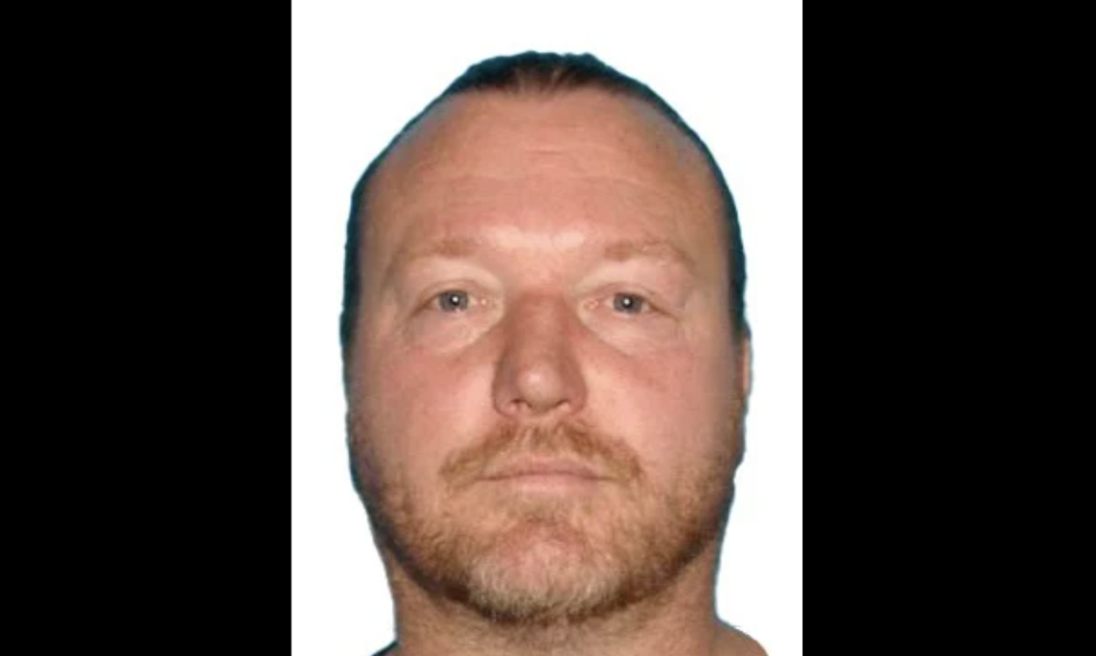 A white man with a short beard looks into the camera.