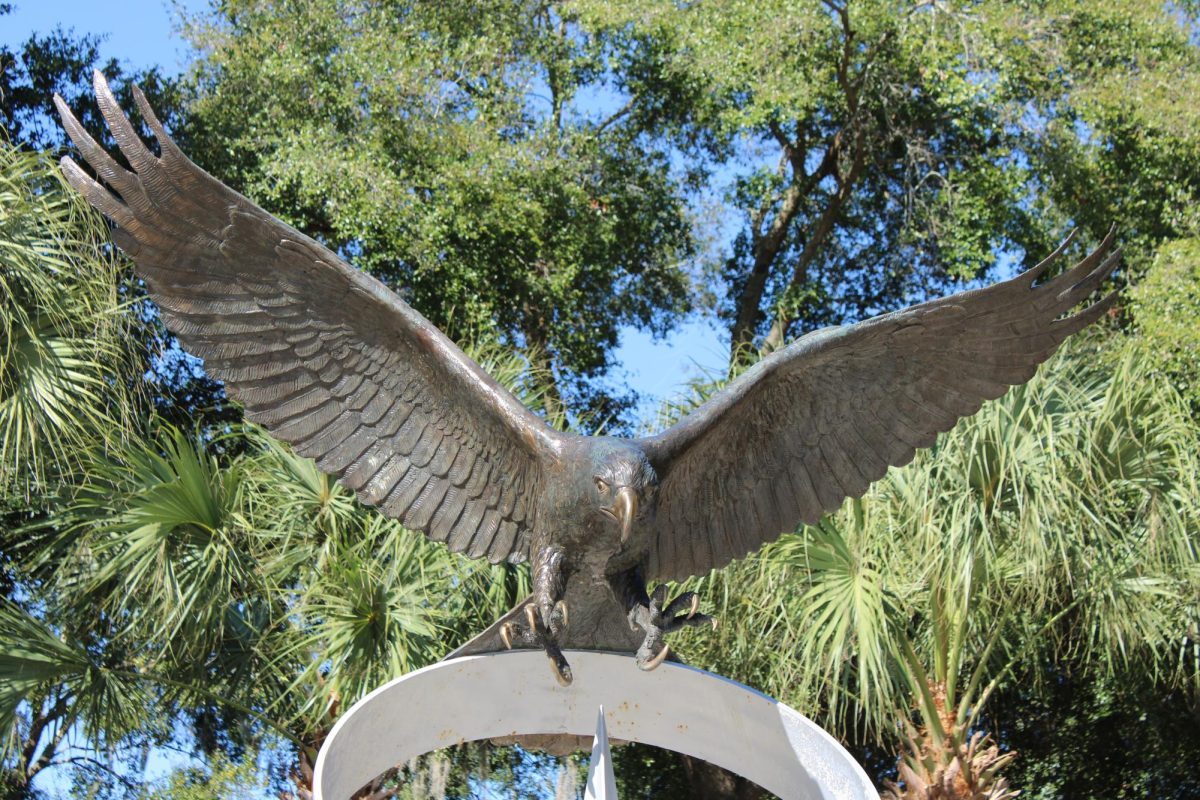 Metal UNF Osprey statue above sits above a decorative fountain with its wing spread