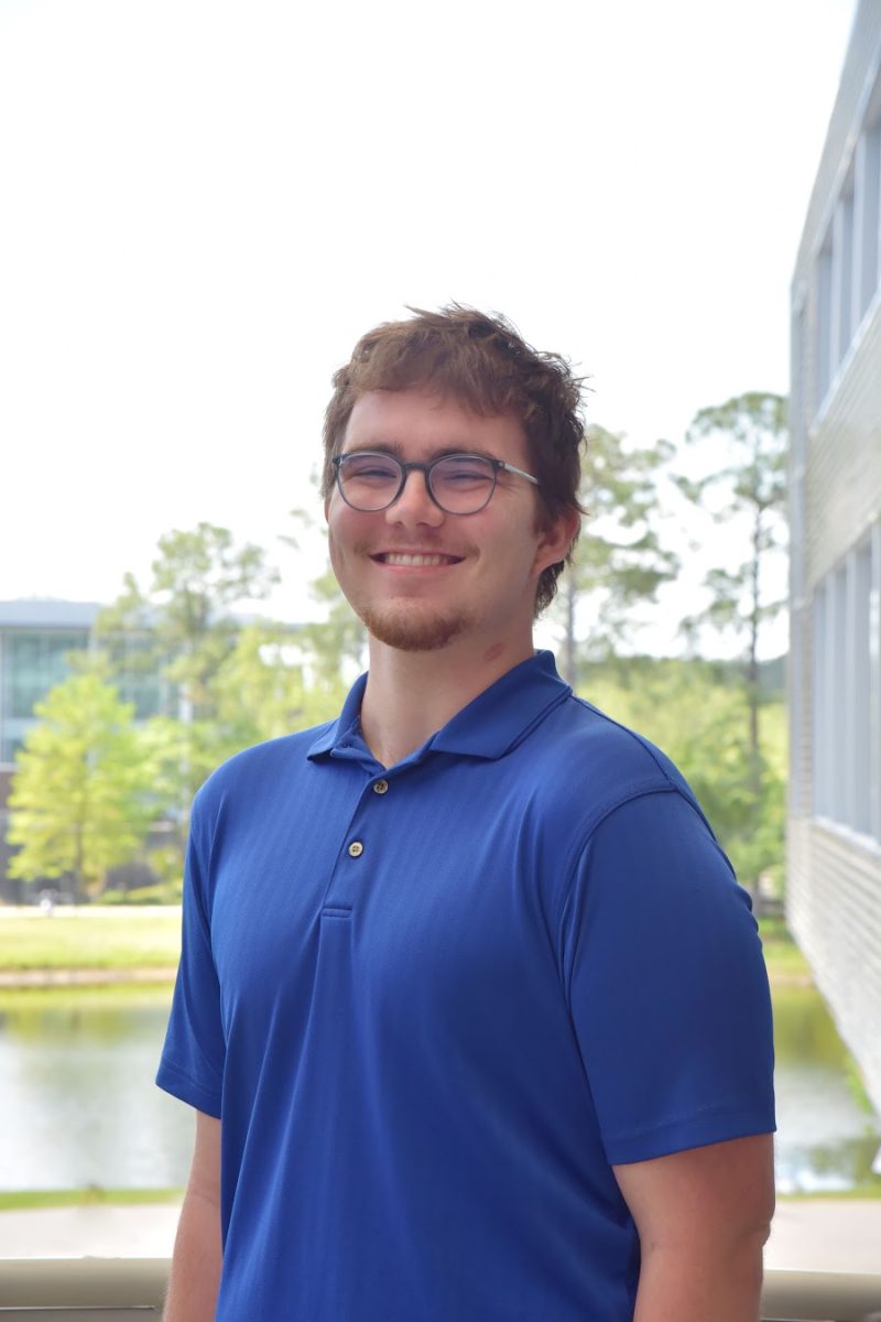 Man wearing blue shirt and glasses.
