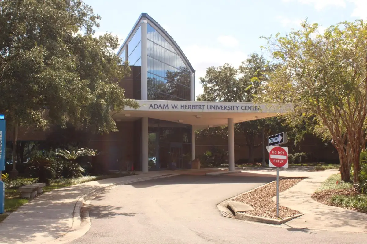 The outside of a large conference building with "Adam W. Herbert University Center" written across the building's entrance.