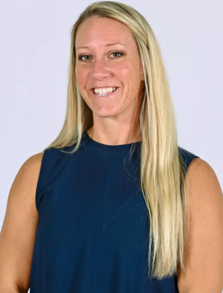 Woman with blonde hair and navy top smiles at camera.