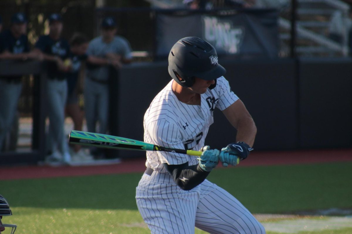 Man in white baseball jersey up to bat.