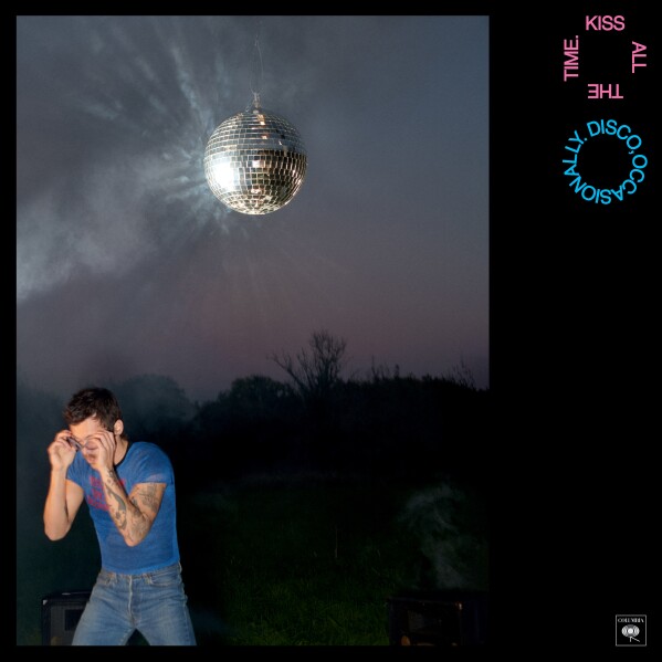 Harry styles outside with disco ball hanging above.