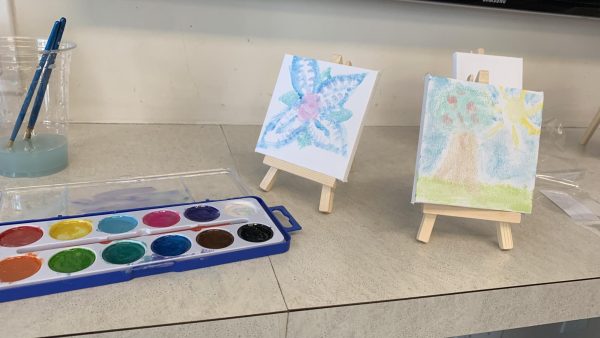 Watercolor tray with two small canves next to it.