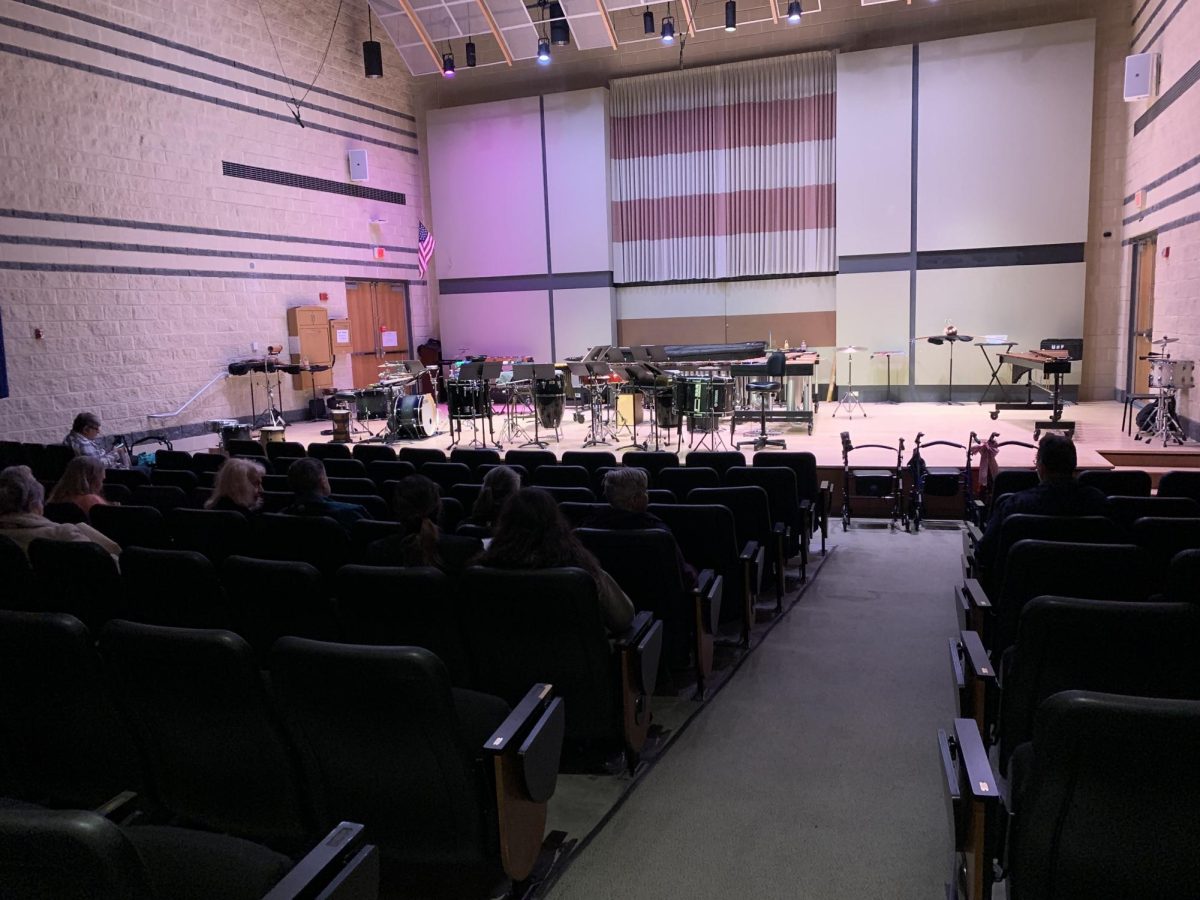 Auditorium with chairs and music stands on stage.
