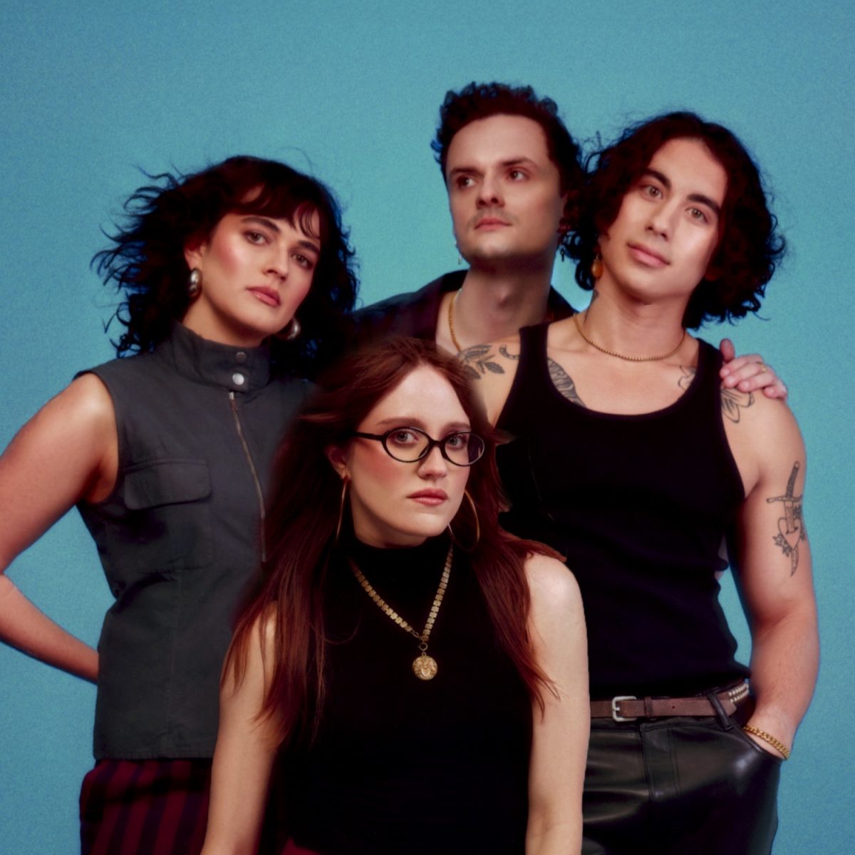Two men and two women in front of a teal background, all wearing gray and black clothing.
