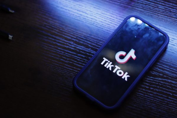 Phone with TikTok logo sitting on a desk.