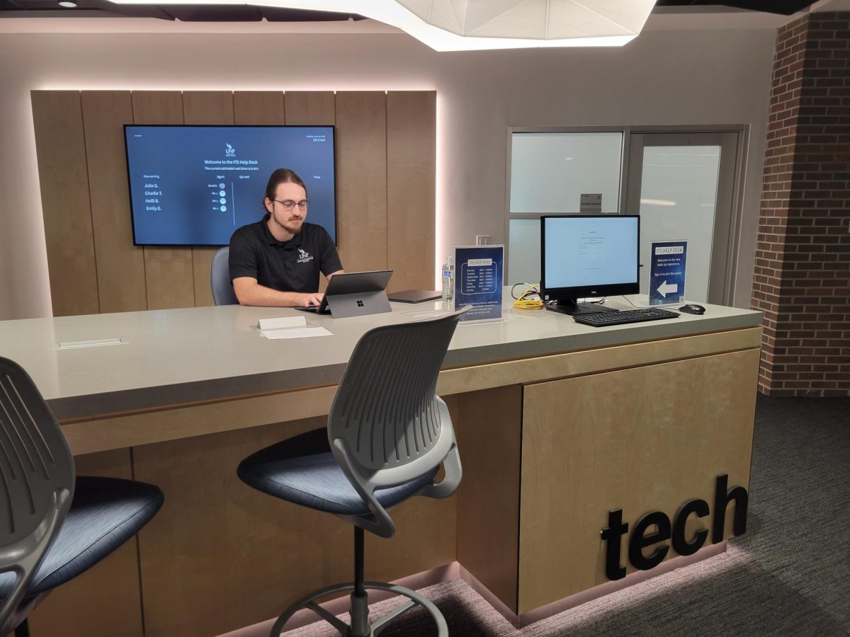 desk with man sitting inside the library.