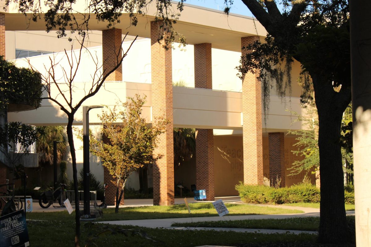 A sunny picture of a brick second story walkway. Shadows of two trees from the image.