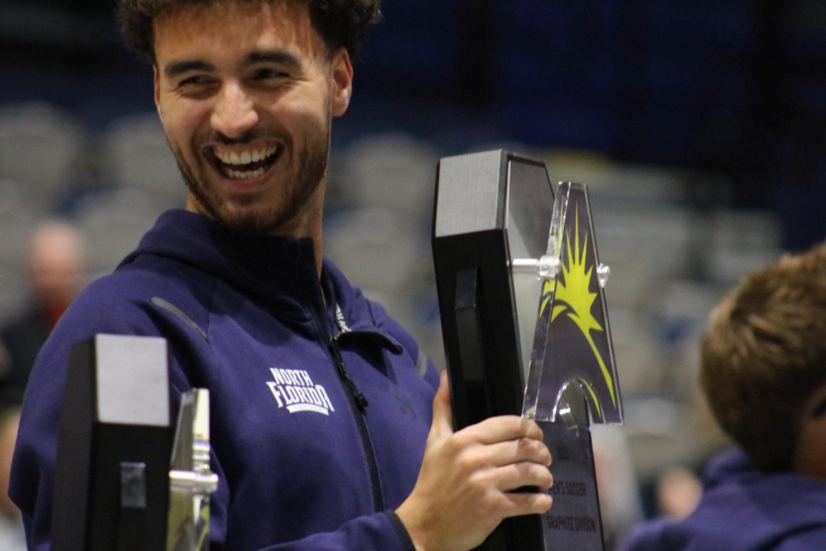 University athlete holding plaque.